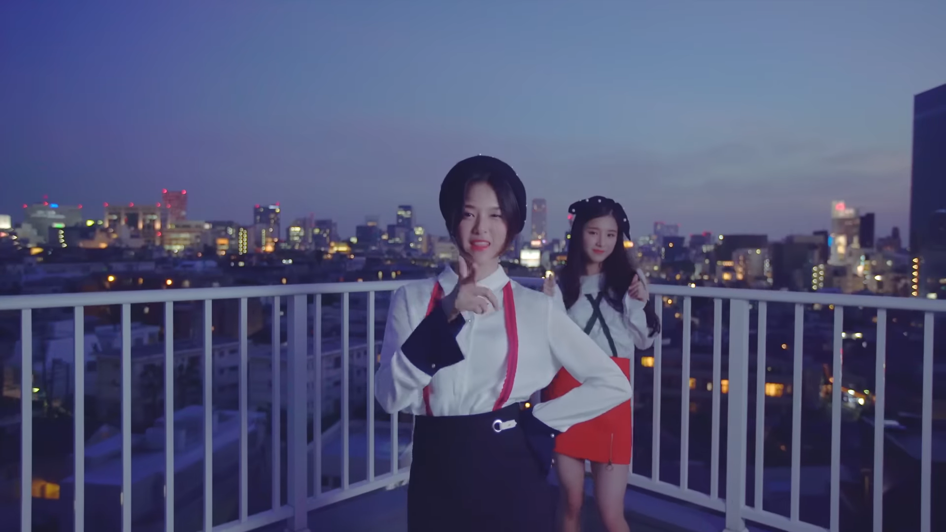 Hyunjin and Heejin standing on a rooftop.